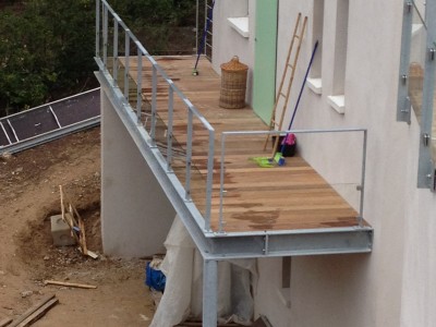 Création d'un escalier d’accès en acier galvanisé et plancher en bois exotique. Garde-corps en acier galvanisé, remplissage en câble inox et soubassement en verre feuilleté. Carry-le-Rouet